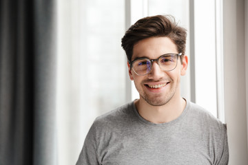 Smiling young man indoors at home looking camera.