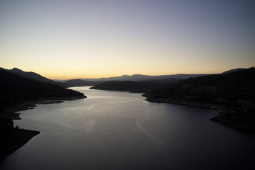 Magnificent view of the Burguillo reservoir at sunset. Popular tourist attraction. Cinematic scene in the middle of nature, located in the Ávila area. The world of beauty.