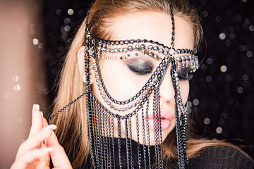 Portrait of a beautiful sexy female with oriental decoration. Model in easterly makeup wore mask of...