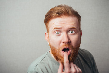 Young hipster red bearded Man finger in mouth