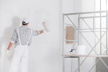 Painter or builder painting a wall white - 339113651