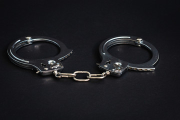 Fototapeta na wymiar Handcuffs on a black background. Close-up. Police handcuffs. Criminal, corruption concept