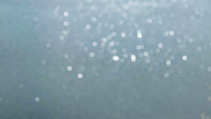 Sun glare on the water in blur.Abstract blue photo in bokeh