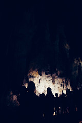 Silhouette of tourists visiting a cave. 