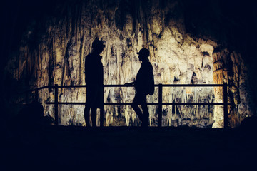 Silhouette of tourists visiting an underground cave. 