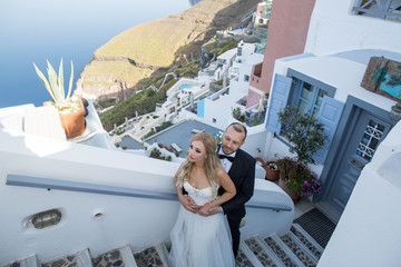 Fototapeta na wymiar Beautiful wedding couple posing on stairs of old beautiful city near sea