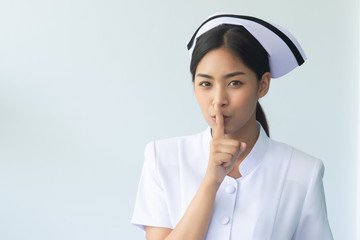 female nurse asking for silence, portrait of asian woman nurse with shhh hand gesture for no noise,...
