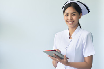 asian woman nurse using smart computer tablet in job; concept of medication with artificial intelligence technology, medical AI in hospital, high technology nurse or medical worker