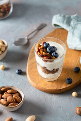 Parfait. Glass with homemade granola with yogurt and fresh berries on concrete background. Dieting, recipe