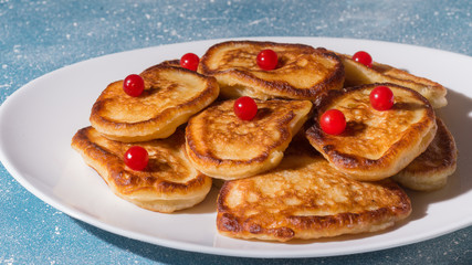 Fritters with berries on a white plate