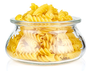 Dried italian pasta spiral Fusilli in a open transparent glass oval storage jar isolated on white background