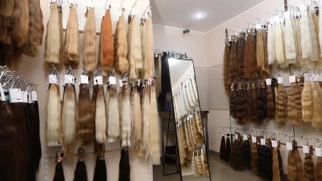 Long fake hair on a bench in a store. Hair Extension Salon