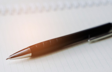 pen and notebook with orange sunlight, writing concept.