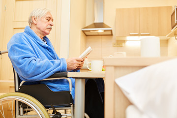 Senior liest Zeitung in Seniorenwohnung
