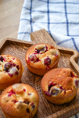Muffins with cranberries and chocolate are beautifully laid out on the cutting Board, around the atmosphere of home and comfort, beautiful interior, natural wood, a Cup of tea