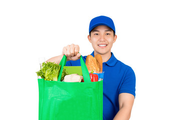 Smiling handsome Asian delivery man holding grocery shopping bag giving to customer isolated on white background