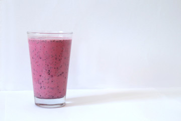 Pink strawberry smoothie in glass on a white background, sports drink after training, protein, bifidobacteria, copy space