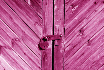 Wooden door with lock in pink tone.