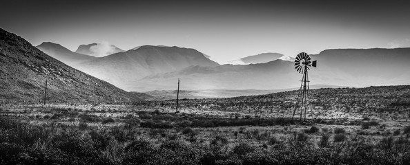 Dry Karoo landscape with windmill in black & white.