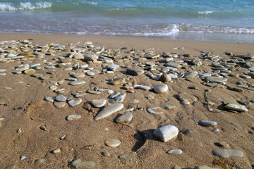 Fototapeta na wymiar Small stones sand and sea wave.