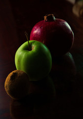 Kiwi, green apple and pomegranate in a line