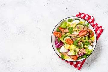 Deurstickers Tuna salad with green leaves, eggs and vegetables. © nadianb