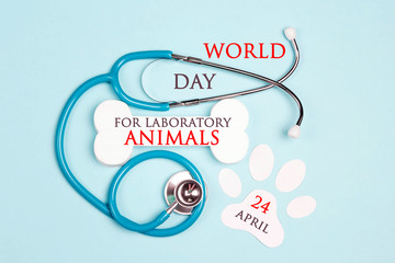 World Day for Laboratory Animals, 24 april. A poster with a stethoscope, bone and paw on a blue...