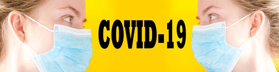 Girl, woman in a blue medical mask looks at the camera, sideways. Girl on a yellow background. Place for text. Copy Space. COVID-19