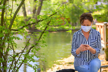 Woman relaxing with a mobile phone in a park
