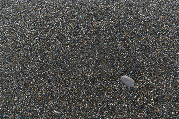 one is not like everyone else. conceptual photo of wet sea shallow pebbles