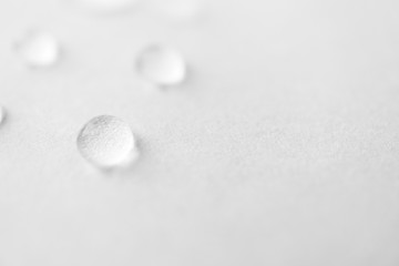 Fototapeta na wymiar Water drops with selective focus on white background, macro. Concept moisturizing close-up. Aqua texture