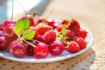 cherry and raspberry berries on a plate