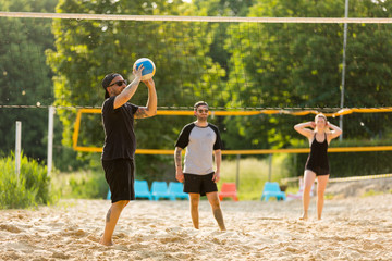 Freunde spielen zusammen Beachvolleyball