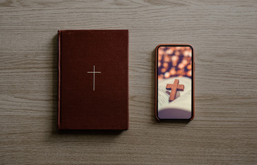 Worship from home, Online live church for sunday service, Top view of mobile screen with wooden cross photo and bible with wooden cross