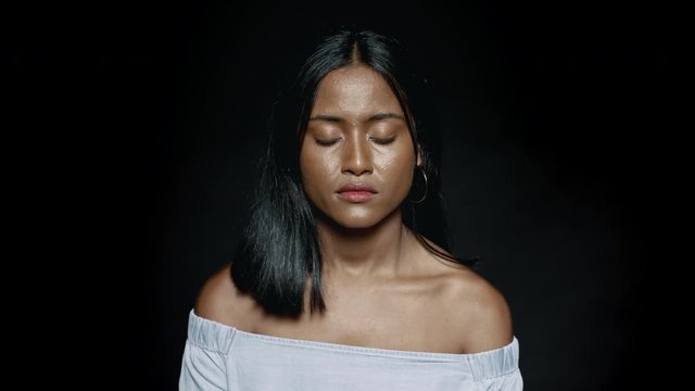 Close Up Of A Young Woman With Eyes Closed On Black Background. African Female Thinking With Closed Eyes.
