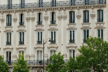 Fototapeta na wymiar Typical old Paris architecture, facades of residential buildings with balconies and mansards, expensive real estate concept. City residents self isolation, deserted streets, european lifestyle