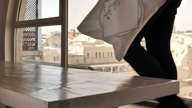 Man take talit pillow from table Temple Mound in Jerusalem, Israel at background