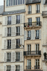 Typical old Paris architecture, facades of residential buildings with balconies and mansards, expensive real estate concept. City residents self isolation, deserted streets, european lifestyle