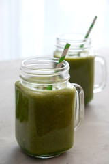 Two glasses with a fresh green smoothie on the table. Healthy diet, snack, nutrition. Vertical orientation