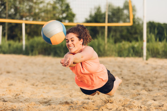Junge Frau am Hechten beim Beachvolleyball