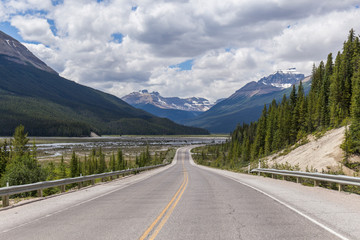 Spectacular road landscapes that run through pine forests and high mountains, Canadian roads with the yellow lines