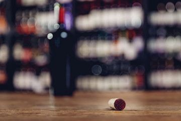 Close-up cork with red wine stone, in background bottle drink of restaurant