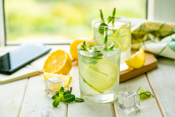 Summer lemonade in glasses in front of window, copy space