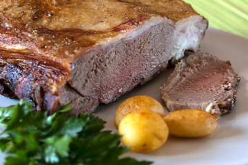 Rosbif con patatas, perejil y especias. Rosbif listo para comer.