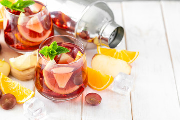 Sangria and ingredients in glasses on wood background, copy space