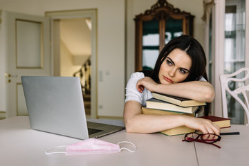 Young woman work at home in quarantine. Woman use laptop on sofa. Woman study distance learning