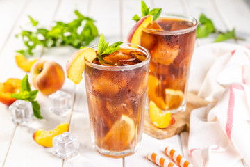 Iced tea and ingredients in glasses on wood background, copy space