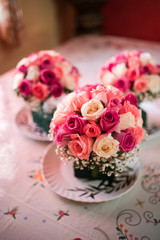 Brides maid's bouquets of pink and red roses, decorated with gold leafs and white flowers.
