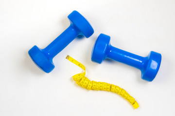 dumbbell and centimeter on a light background