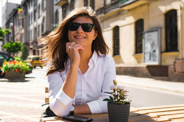 Portrit of smiling young woman sitting in outdoors cafe